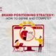 An illustration of a team collaborating on a monitor, representing the process of creating a Brand Positioning Strategy.
