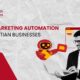 A smiling professional using a laptop next to a small red robot holding envelopes, representing Email Marketing Automation.