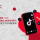 An illustration of a man in a yellow shirt standing next to a large red smartphone displaying the TikTok interface, representing TikTok Ads for E-commerce in Egypt.
